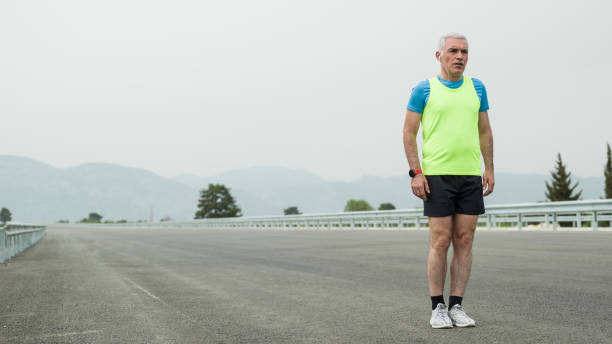 istock Mature Adult Man Getting Ready For Running On Asphalt Road 942806512