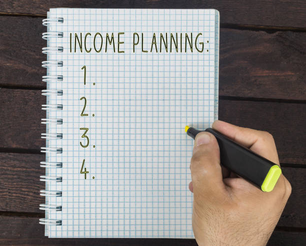 istock male hand is writing income planning on a notepad 942808918