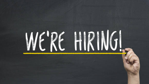 istock Human's hand writing We're hiring on blackboard 942808926