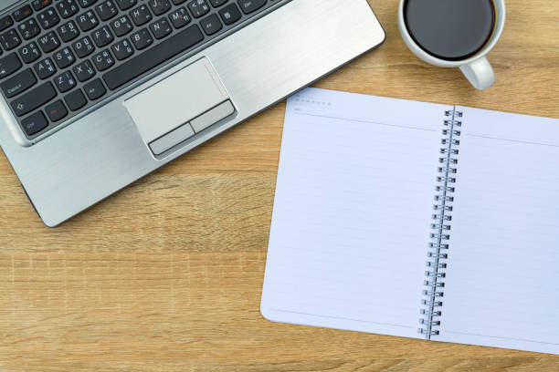 istock Laptop computer or notebook, note and cup of coffee on working table with copy space top view. 942809022