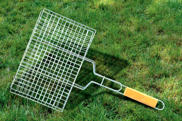 Steel grill rack isolated on grass in garden.