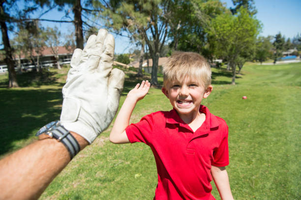 junior golfer high five - categoria juniores foto e immagini stock