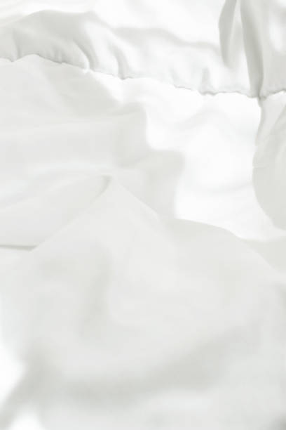 istock White Cotton Blanket in Bedroom with Bright Morning Sunlight Streaming through Window. Highlights Leaks. Blank Template for Poster Banner. Energy Waking up Relaxation Purity Concept. Copy Space 942839302