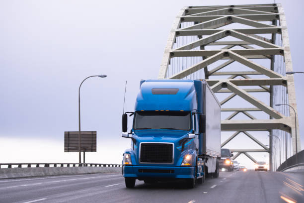 голубая большая буровая полугрузовик, перевозящий полуприцеп на арочный мост фримонт - industry pacific northwest usa built structure стоковые фото и изображения