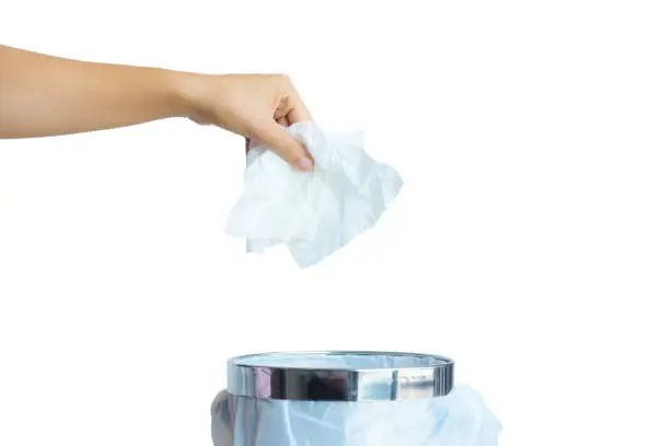 Women hand throwing white tissue paper in to a trash bin isolate on white background.