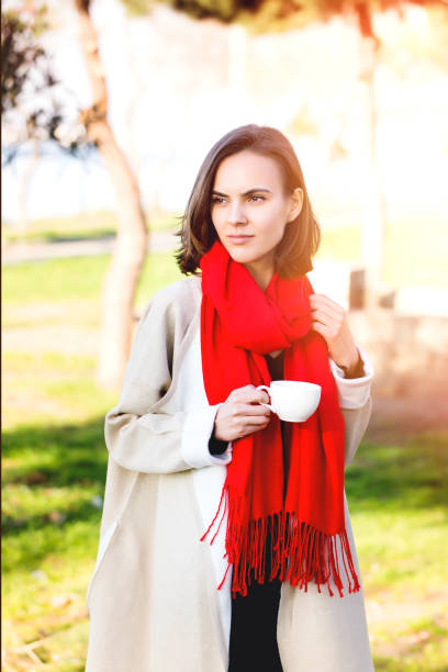 istock Young woman drinking coffee at park with sunset 942846854