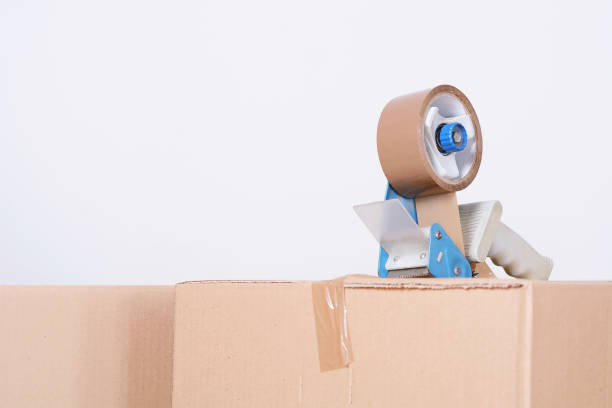 istock Tape dispenser sealing a shipping cardboard box 942847138