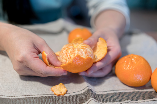 girl peeling off fresh orange