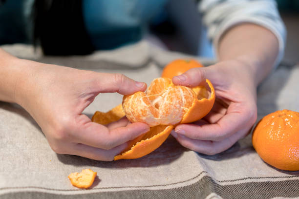 istock girl peeling off fresh orange 942852690