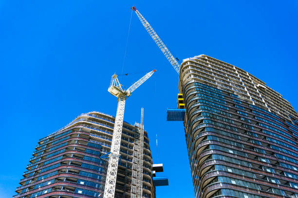 istock Looking up the tall skyscraper building and hoisting cranes 942853460