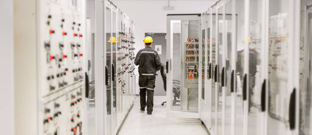 à l’aide de relais de protection et appareillage électrique de moyenne tension. département d’ingénierie - telecommunications equipment technician repairing engineer photos et images de collection