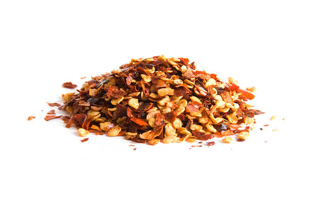 Pile of crushed red pepper on white  red bell pepper stock pictures, royalty-free photos & images