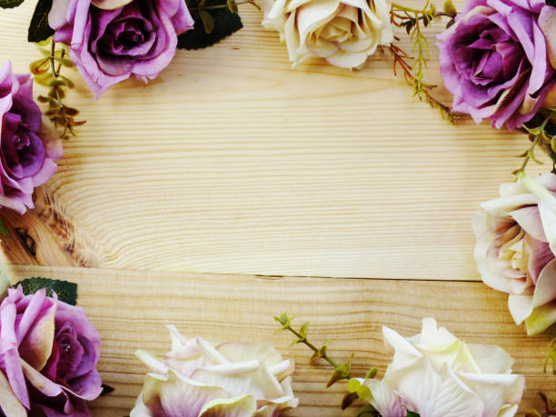 istock artificial purple rose flowers border on wooden background with space copy 942869714