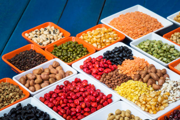 istock Different dry legumes in container on blue plank, Prepared multicolor dried beans ontable for cooking 942870256