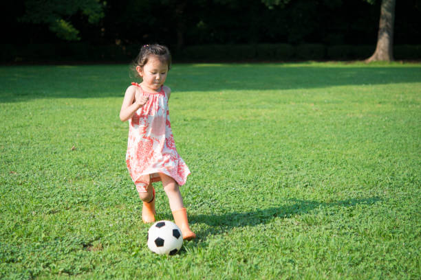 istock Little girl playing with a soccer ball 942874532