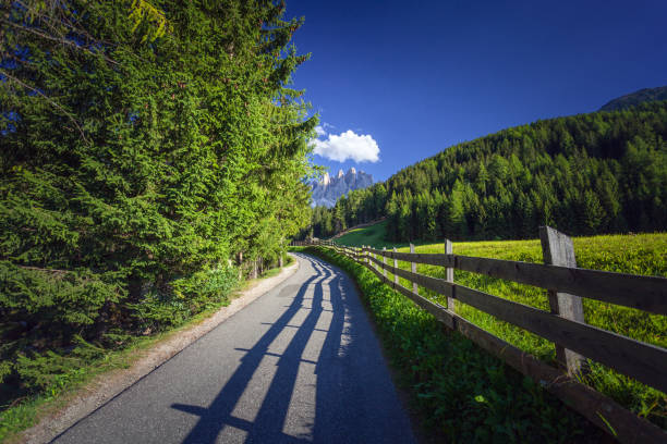 прогулка в валь-ди-фунес - country road fence road dolomites стоковые фото и изображения