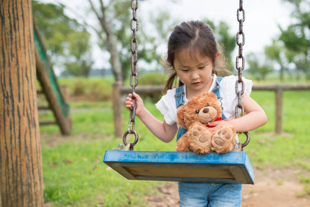 istock Little girl playing with teddy bear 942877774