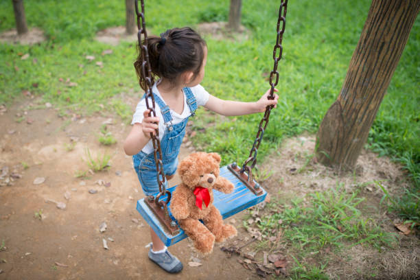 istock Little girl playing with teddy bear 942877778