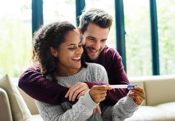 couple heureux avec des nouvelles de la grossesse - human pregnancy photos et images de collection