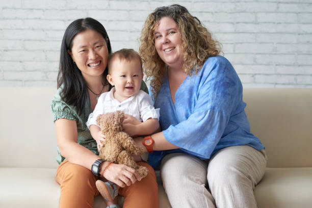 Happy family Happy multi-ethnic female couple with their adorable baby boy lesbian stock pictures, royalty-free photos & images