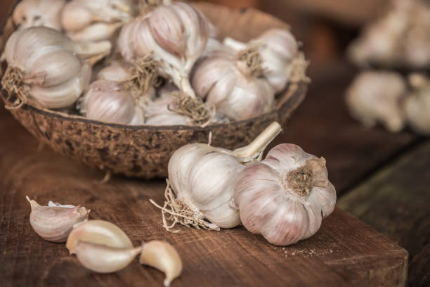 istock Garlic bulbs. Fresh garlic with  on wood board. 942882928