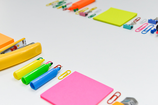Office or school stationary including paper note, paperclip, and highlighter with copy space