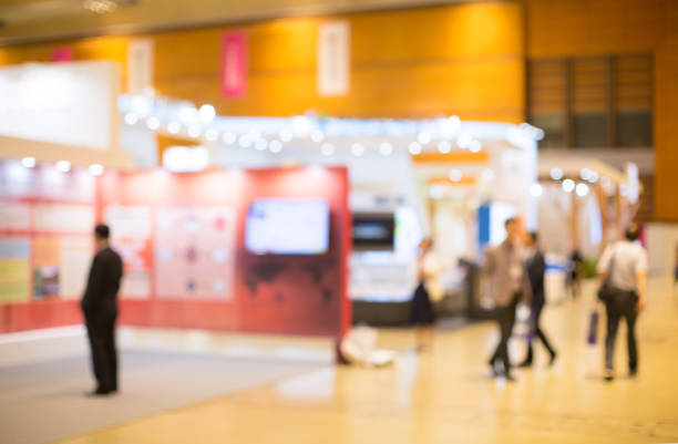 Nicely Lit Display Exhibits and Professional People Looking and Walking Around stock photo