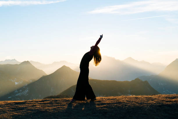 danses de la femme au lever du soleil dans les montagnes - grâce photos et images de collection