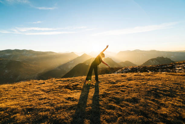 istock Woman dances at sunrise in the mountains 942893128