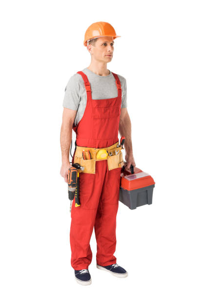 istock Professional builder in overalls and hardhat holding toolbox and drill isolated on white 942893488
