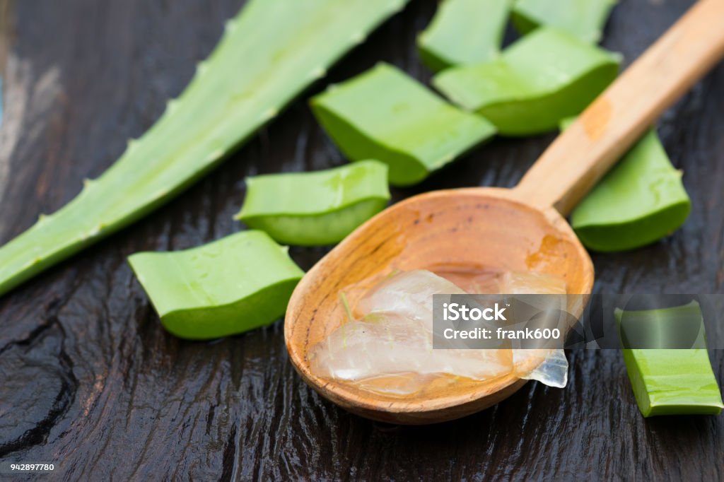 gel de Aloe vera en la cuchara de madera con aloe vera en la mesa de madera - Foto de stock de Aloe vera libre de derechos