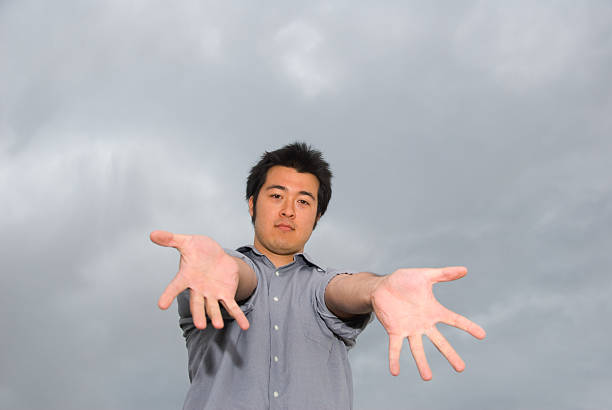 istock Man with outstretched hands aganst stormy sky 94289813