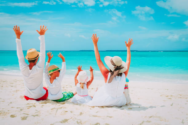 istock happy family with two kids hands up on beach 942908214