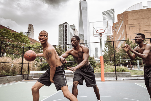 friends playing street basketball in nyc