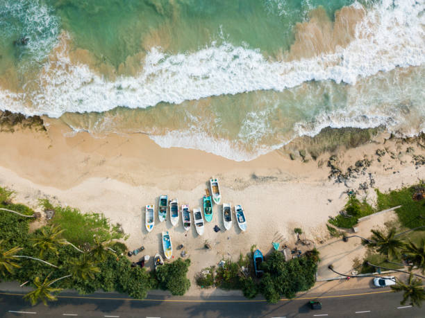 bela praia com águas turquesas e barcos de pesca na praia. estrada da costa do oceano. vista aérea, fotografia de zangão - pacific coast highway - fotografias e filmes do acervo