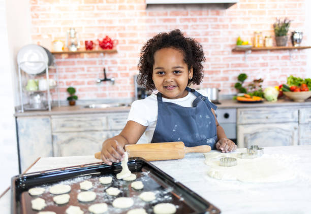 istock Little girl making cookies at home 942909868