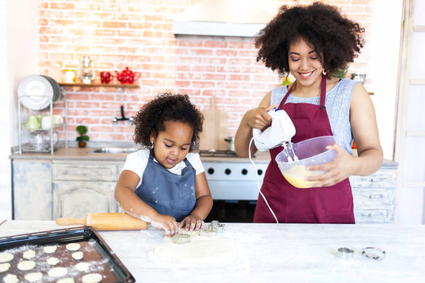 istock Mother and daughter mixing cookies 942909872