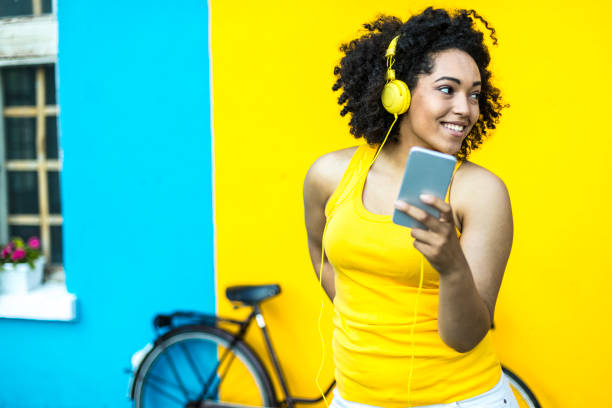 istock Smiling woman with bike using smart phone 942909956