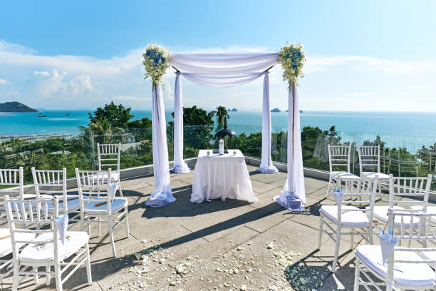 istock Wedding venue setting, Arch and altar decorated with roses, flowers, ocean background 942915858