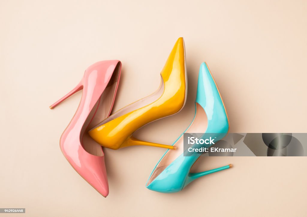 Set of colored women's shoes on beige background Bright colored women's shoes on a solid background. Copy space text. Shoe Stock Photo