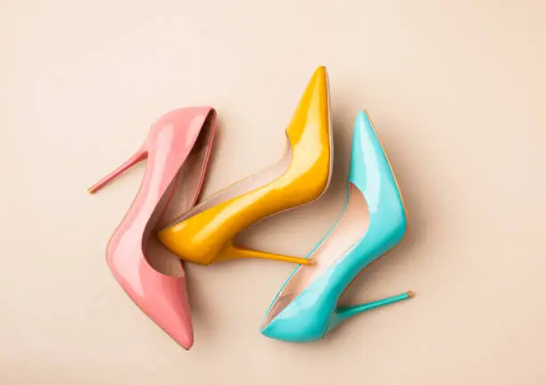 Photo of Set of colored women's shoes on beige background