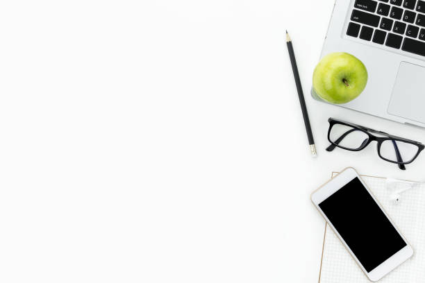 istock White office desk table with laptop, apple, and supplies. Top view with copy space, flat lay. 942926806