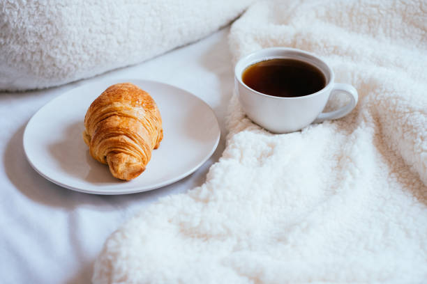 istock Coffee and croissant in bed 942927434