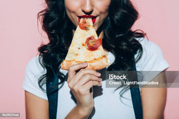 Foto de Cortada A Foto Da Mulher Comer Pizza No Fundo Rosa e mais fotos de stock de Pizza - Pizza, Só Uma Mulher, Itália