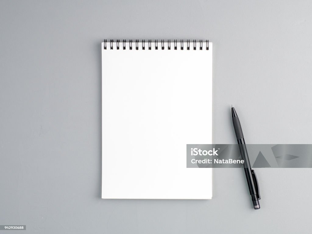 hoja en blanco del cuaderno con espiral y pluma en un fondo texturado gris neutro - Foto de stock de Cuaderno de apuntes libre de derechos