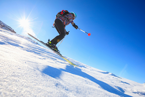 Woman snow skier skiing at sunny ski resort Amateur Winter Sports. High mountain snowy landscape.  Italian Alps mountain of the Dolomites Madonna di Campiglio, Italy.