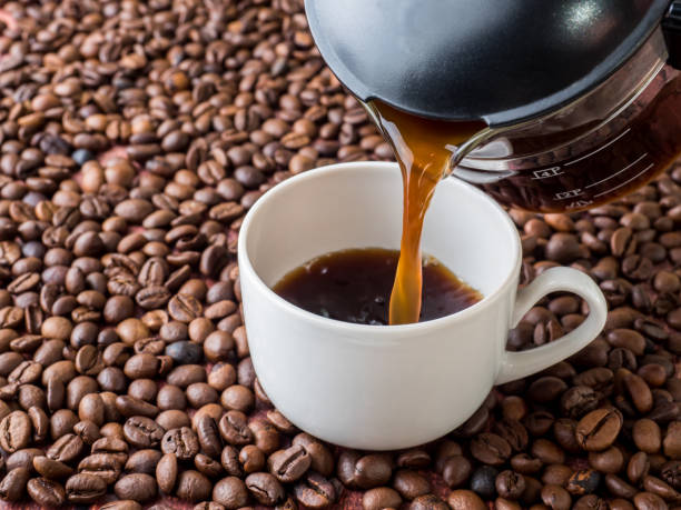 istock Cup and pot of coffee on coffee beans background 942937812