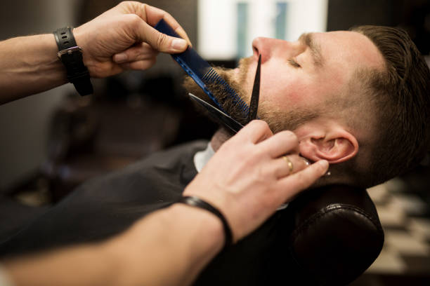 istock Young man having beard trimmed at barber salon 942938746