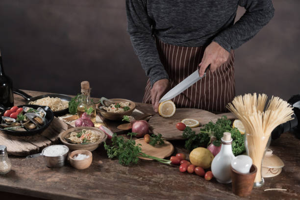 istock Handsome bearded cheef cook prepairing spaghetti on a kitchen, Chef cooks meal 942949174