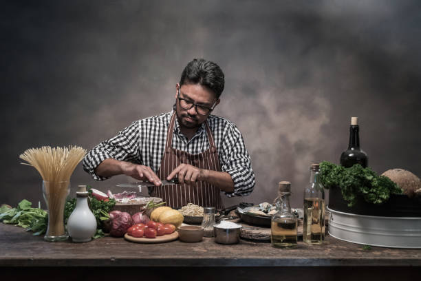 istock Handsome bearded cheef cook prepairing spaghetti on a kitchen, Chef cooks meal 942949200